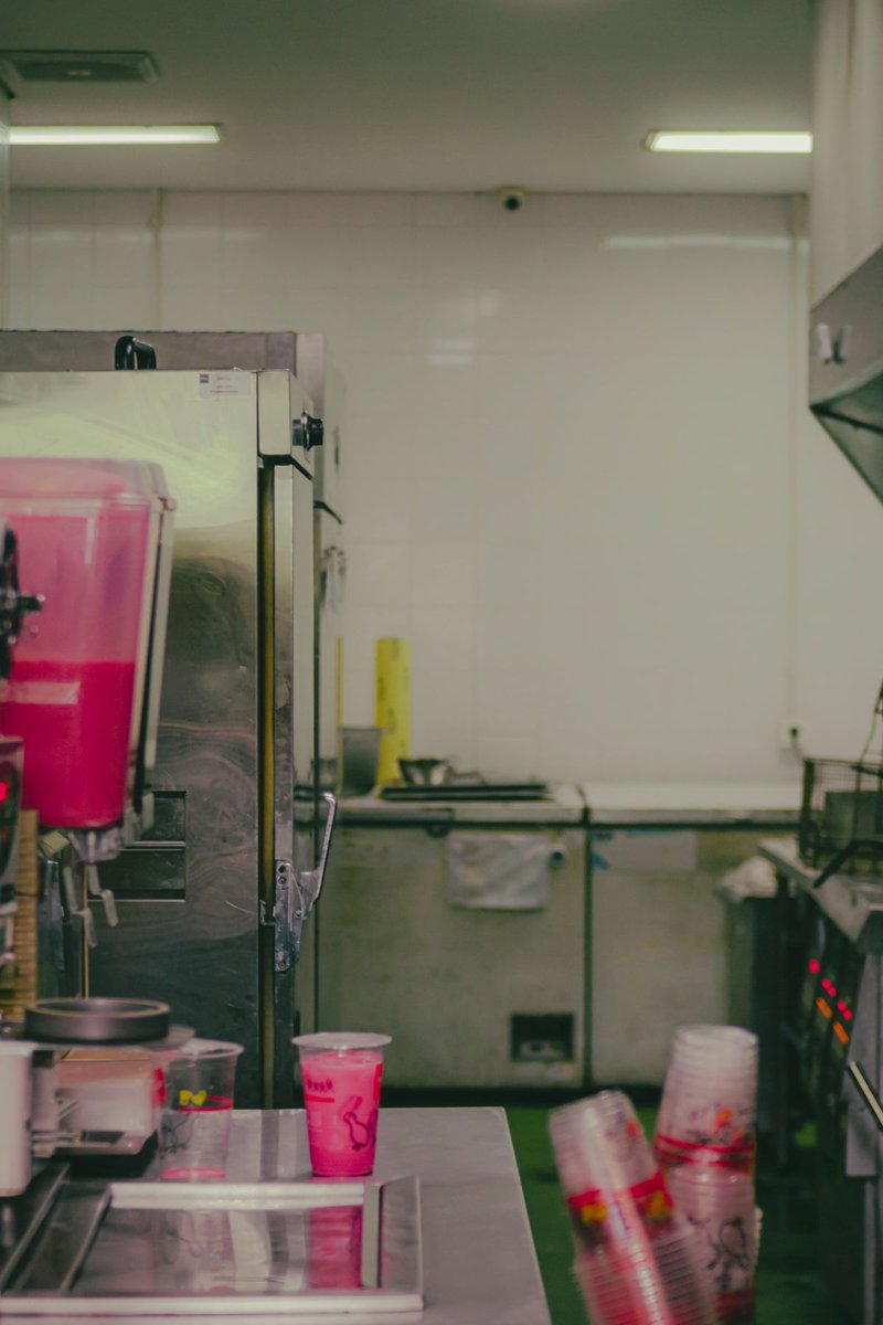 A clean commercial kitchen with stainless steel counters and beverage machines